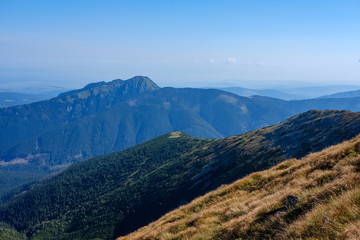 Naklejka premium mountain top panorama in autumn covered in mist or clouds