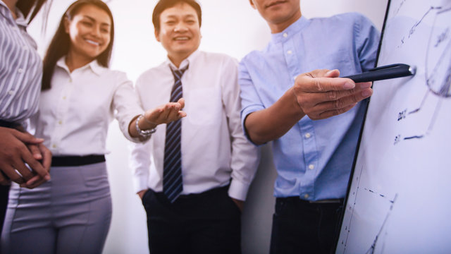 Young creative business people brainstorming ideas at the board.