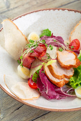 Fresh salad with chicken breast, arugula and tomato. Top view