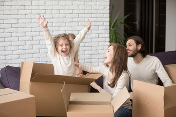 Happy family together in living room. Funny joyful young first time buyers playing with children....