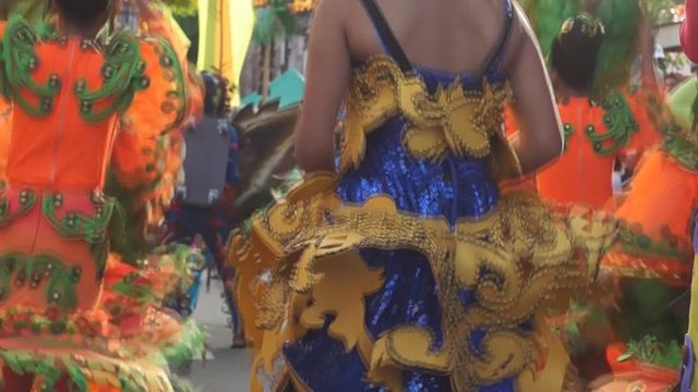 group of carnival folk and cultural dancers in colorful handcrafted coconut costume dance along the streets to honor a patron saint. Public Event