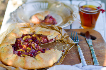Sand cake with apples, figs, cinnamon and viburnum. Autumn baking. Tea pie on white wooden table outdoors