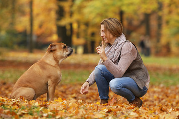 Middle age woman doing tricks with her dog