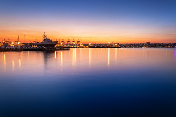 View of the ships in Durban harbor at sunset with colored lights reflecting in the water, Durban, South Africa.