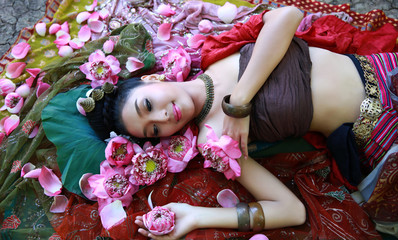 Cute asia women wearing Thai traditional dress line down on floor Surrounded by lotus flowers present traditional beauty concept