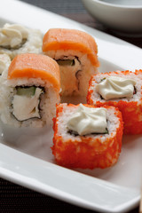 Traditional japanese seafood, roll are lying on a white plate. Close up.