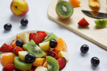 Healthy breakfast with kiwi, oranges, plums and other fruits.
