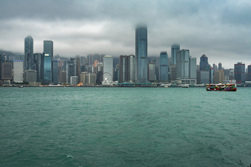 Fototapeta premium Malownicze niskie chmury nad panoramą Hongkongu Central widziane z molo Kowloon Public Pier. Hongkong, styczeń 2018 r