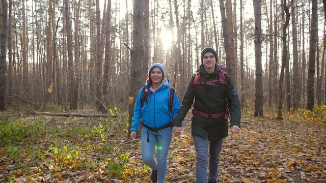 Hiking and Backpacking concept. Young Couple of travelers walking in forest in autumn day