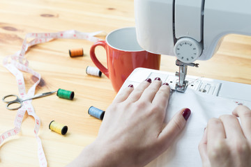 Close up of young woman working on a sewing machine