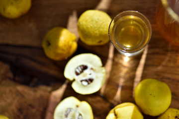 einture de coing d'or dans un verre à côté du fruit de coing