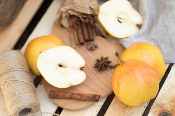  juicy ripe pear with cinnamon and thyme on a wooden background