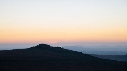 Naklejka na ściany i meble Stunning sunset silhouette landscape image of Foggintor in Dartmoor