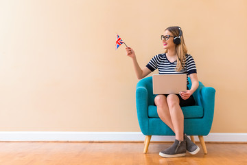 Young woman with UK flag using a laptop computer in a chair
