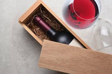 Schilderijen op glas Cabernet Wine Box: A single bottle of red wine in a wood box partially covered by its lid © Steve Cukrov