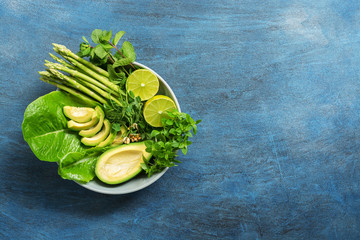 Detox Buddha bowl with avocado, asparagus, micro greens, lime, lettuce, basil and mint.Dietary food. Blue rustic background, top view.