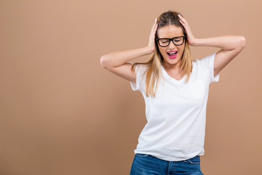 Young Woman Blocking Her Ears On A Brown Background