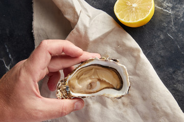 Man opening fresh oyster