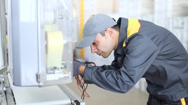 Mechanic fixing a machinery in an industrial environment