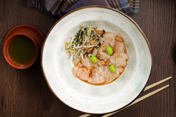 Plate with scallops and nuts in an Asian restaurant