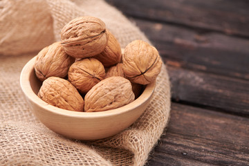 Walnuts on dark vintage table, Walnuts kernels in wooden bowl. Walnut healthy food