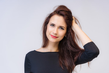 Fototapeta premium Studio portrait concept of a smiling beautiful brunette girl talking on a white background.