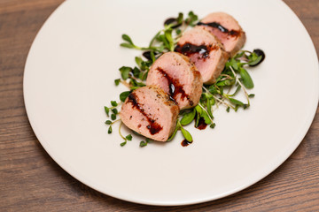 Hot Pork Tenderloin with Herbs and Spices on white plate with sauce. Selective focus. Food background