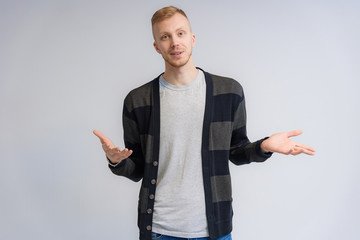 Studio portrait concept of a smiling young man talking on a white background.