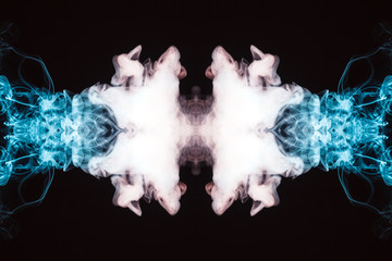 Abstract thick colored smoke on a black background with a monster face. The concept of light laser...