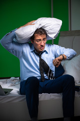 Young businessman under stress in the bedroom at night