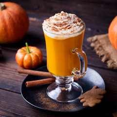 Pumpkin smoothie, spice latte. Boozy cocktail with whipped cream. Wooden background. Close up.