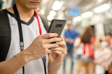 Traveler man using smartphone at a train station , Transportation and travel lifestyle concept