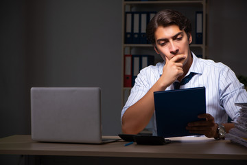 Young financial manager working late at night in office 