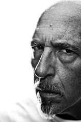 Obraz premium Back lit three quarter portrait of man looking at viewer with serious expression. Shallow depth of field.