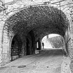 Figure walking away through and old archway