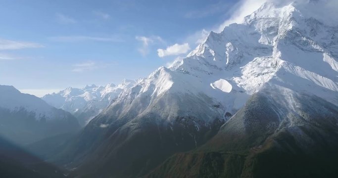 Slow drone aerial pan up right to reveal of Annapurna II mountain peak and snow face in high altitude Himalayan landscape seen from 4000m elevation at Ghyaru village, Nepal. 4k 1.9:1 23.976fps