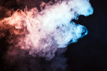 Colored smoke on a black background. The concept of light show at a music concert