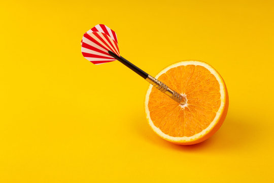 orange slice, fruit with circular target marked and dart on yellow background. minimal idea food and fruit concept. Idea creative to produce work and advertising marketing communications