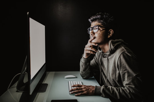 Indian hacker using computer white screen trying to commit computer crime. Hacker and computer threat crime concept
