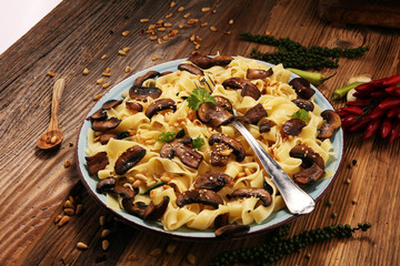 Pasta fettuccine with mushrooms and spinach on rustic background.