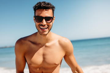 Close up of a shirtless man enjoying at the beach