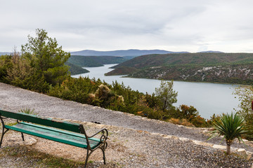 Obraz premium resting place near the river, which runs through the mountains; view of the recreational benches in the view of the river; view from top to river and mountains.