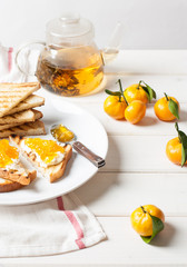 French toast with fresh orange, cream cheese and tea on white plate. Tasty breakfast
