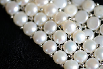 White pearl necklace on a dark background close up
