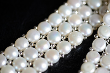 White pearl necklace on a dark background close up