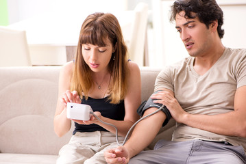 Obraz na płótnie Canvas Wife checking husband's blood pressure 