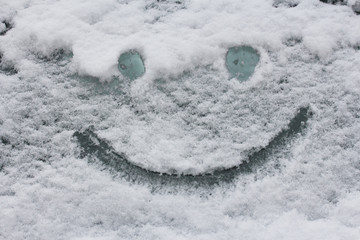 Smiley face on snow surface. Winter concept.