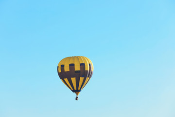 Colorful hot air balloon flying in blue sky. Space for text
