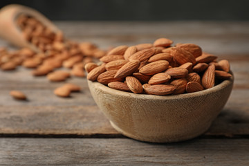 Tasty organic almond nuts in bowl on table