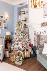 Interior living room with a Christmas tree and decorations.Beautiful holdiay decorated room with Christmas tree with presents under it.New Year's interior with a fir tree in white ,pastel tones